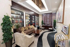 A modern living room with a sofa, coffee table, and a bookshelf. - Jiuzhou Tongqu Hotel (Wuhan)