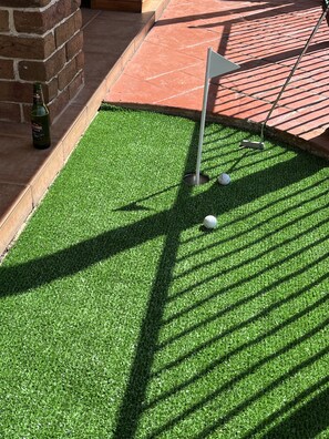 Play a round of golf in a well-maintained course with a flagstick at the start of each hole.
