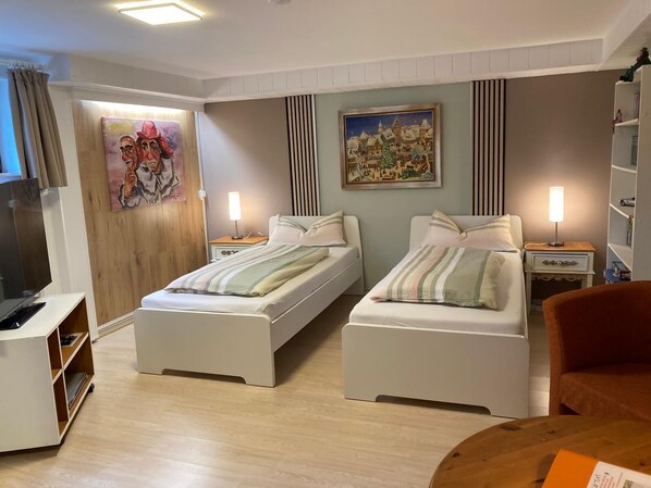 A bedroom with two beds, a desk, a chair, and a bookshelf. - Fe apartm., in a quiet location, 5 minut. from the S-Bahn + Regio train station (Meckesheim)