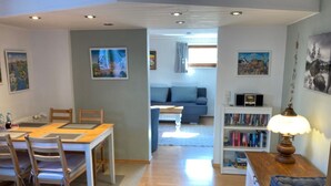 A modern living room with a dining area, a bookshelf, and a cozy seating area. - Fe apartm., in a quiet location, 5 minut. from the S-Bahn + Regio train station (Meckesheim)