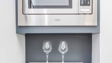 Een moderne keuken met een ingebouwde magnetron en een zwarte koelkast.