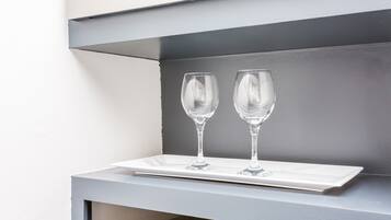 A white tray with two clear wine glasses on a grey surface.
