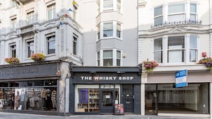 A street view with a building labeled "The Whisky Shop" and another building with a sign "Graves Jenkins." - Studio In the Lanes (Brighton)