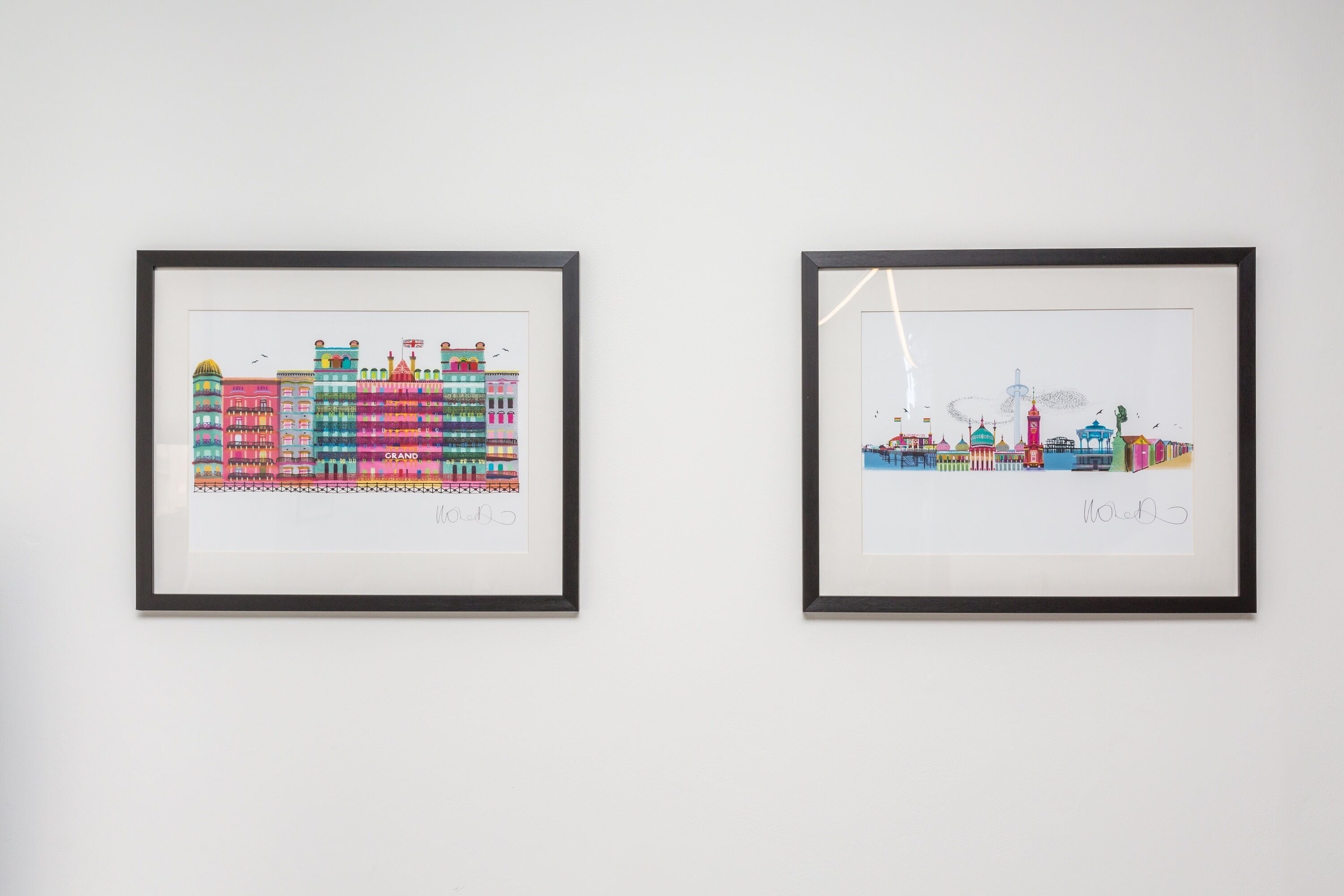 Two framed artworks on a wall.