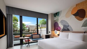 Habitación de hotel moderna con una cama grande, una mesita, una silla y vistas al exterior.