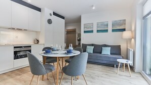 A modern living space with a kitchen, dining area, and a sofa set. - Apartamenty Swinoujscie – Lissa (Swinoujscie)