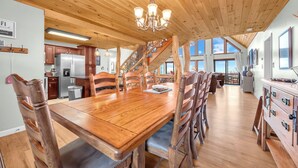 A spacious kitchen with wooden cabinets, a large dining table, and a chandelier. - Upscale Home With Expansive Mountain Views (Banner Elk)