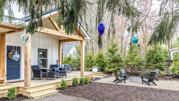 A covered outdoor seating area with wooden furniture and a small garden.