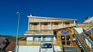A hotel with a wooden facade, balconies, and a sign reading "la vallée blanche". - La Vallée Blanche (Huez)