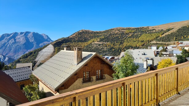 A wooden chalet with a balcony, surrounded by a mountainous landscape and a clear sky. - La Vallée Blanche (Huez)