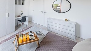 Ein modernes Schlafzimmer mit Bett, Schreibtisch, Kommode und Spiegel.