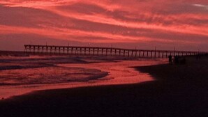 A pier extending into the water with a sunset sky. - Cozy 3BR oceanfront home in Holden Beach, perfect for family getaways. (Holden Beach)