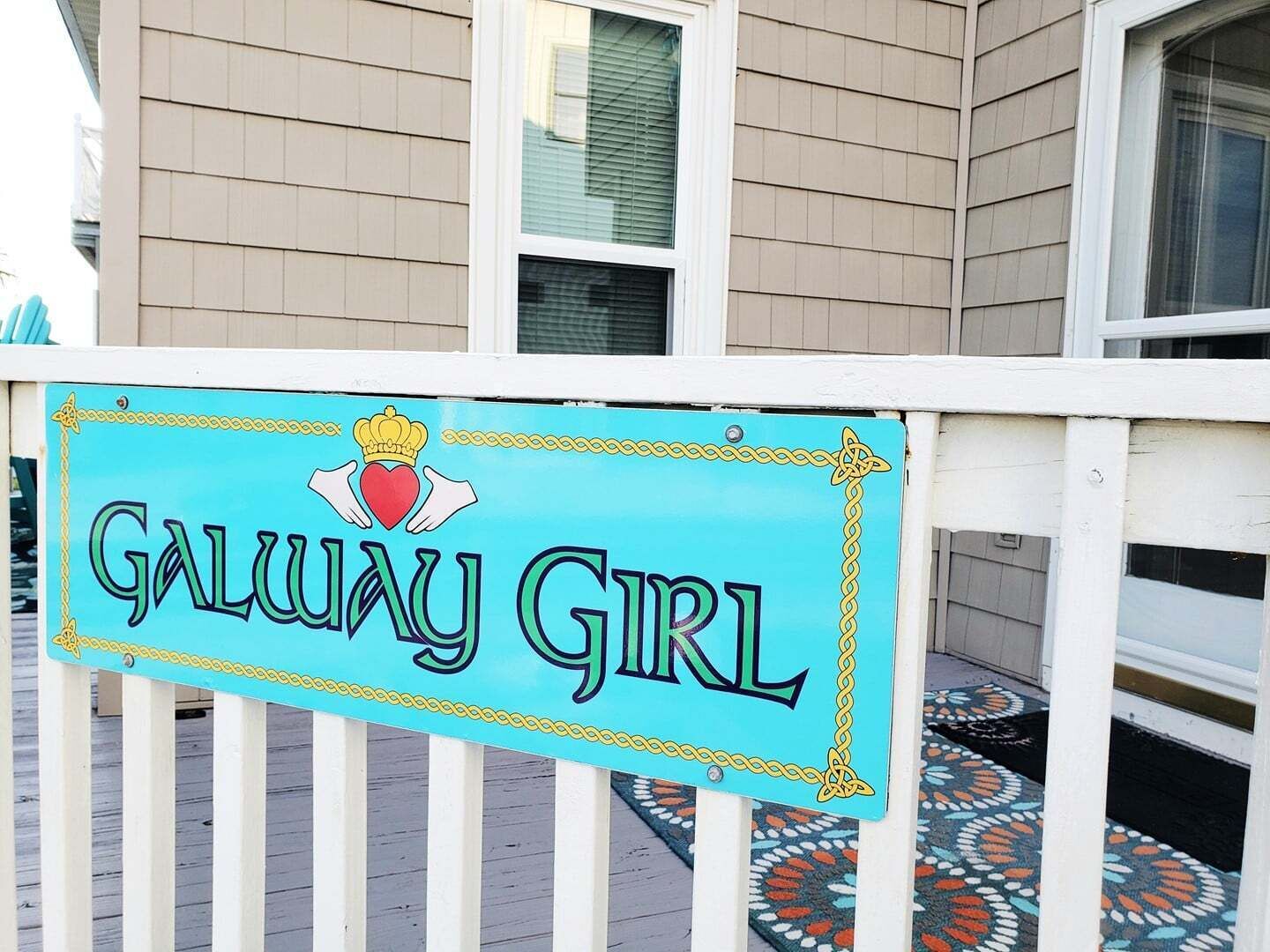Ein Schild mit dem Aufdruck 'GALWAY GIRL', das an einer weißen Geländer angebracht ist.