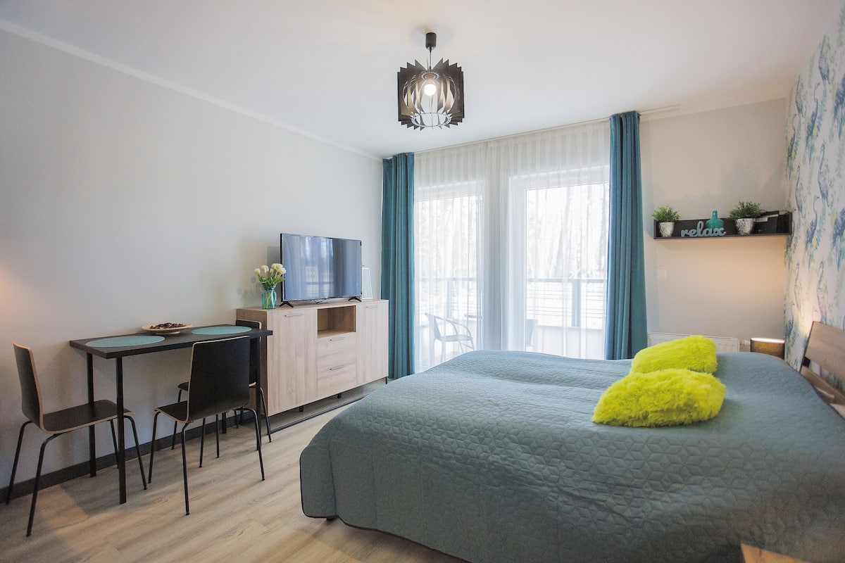 Ein Schlafzimmer mit Bett, Schreibtisch und Fernseher.