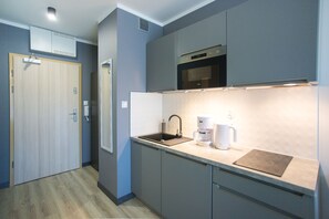 Standaard studio | Privékeuken | Een mini-koelkast, een waterkoker, kookgerei, borden en bestek