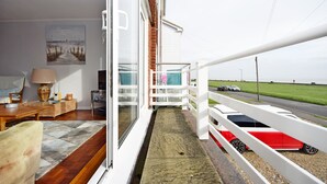 A balcony with a view of the road and a red car parked outside. - Sea Breeze, Selsey -  a town house that sleeps 6 guests  in 3 bedrooms (Chichester)