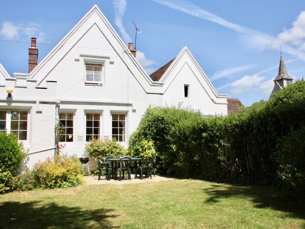 A white two-story house with a garden and a small table and chairs in the front yard. - Pepper Pot Cottage , Compton - a cottage that sleeps 6 guests in 3 bedrooms (Chichester)
