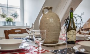 A dining table with a pitcher, wine bottle, and glasses.