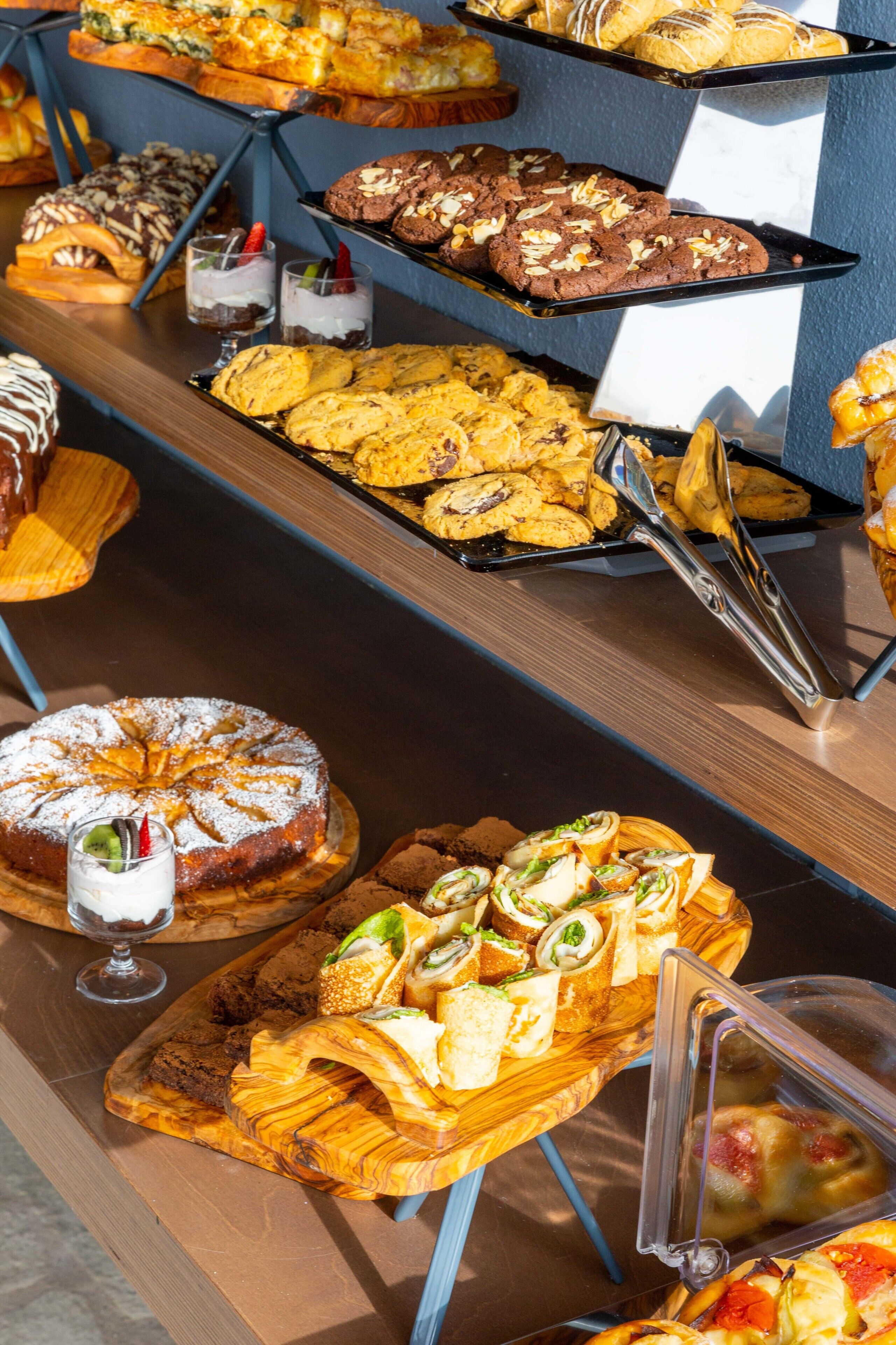 A buffet with various baked goods, including cakes, pastries, and cookies.
