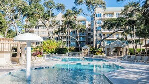 A pool area with multiple swimming pools, lounge chairs, and a covered seating area.