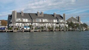 A waterfront property with multiple houses connected by a dock. - Harbour Island 103L-Baywater 14th St, WIFI, Pool, Elev, W/D, AC (Ocean City)