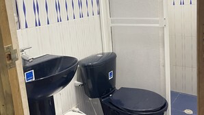 A bathroom with a black sink, a toilet, and a shower area. - Welcome to real paradise (San Luis)