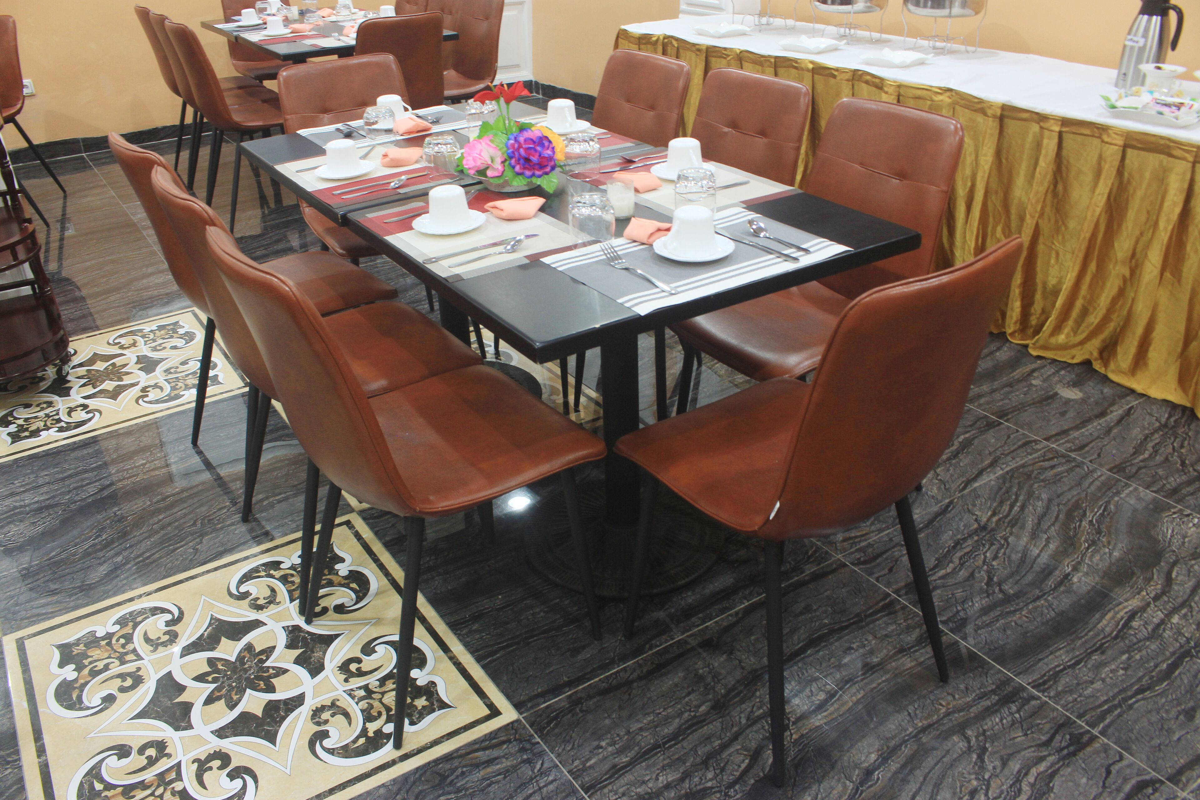 A dining area with a long table set for multiple people, surrounded by brown chairs.