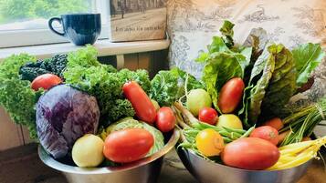 Two metal bowls filled with fresh vegetables on a windowsill.