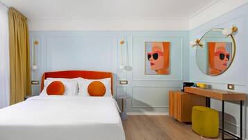 Een hotelkamer met een bed, bureau, stoel en spiegel.