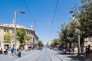 Una calle con vías de tranvía, edificios y peatones.