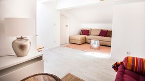 Una sala de estar moderna con un sofá, una mesa de centro y un jarrón decorativo.