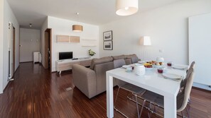 Un appartamento moderno con zona living, sala da pranzo e cucina.