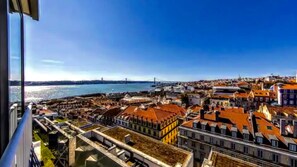 A coastal cityscape with a prominent bridge, colorful buildings, and a view of the sea. - Full Sky in Chiado by LovelyStay (Encarnação)