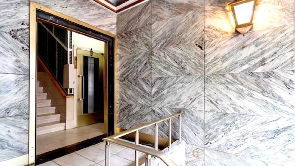 A marble staircase leading to a room with a view of the outside. - Full Sky in Chiado by LovelyStay (Encarnação)