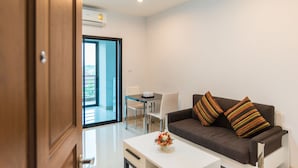 A modern living room with a sofa, a coffee table, and a view of a balcony.