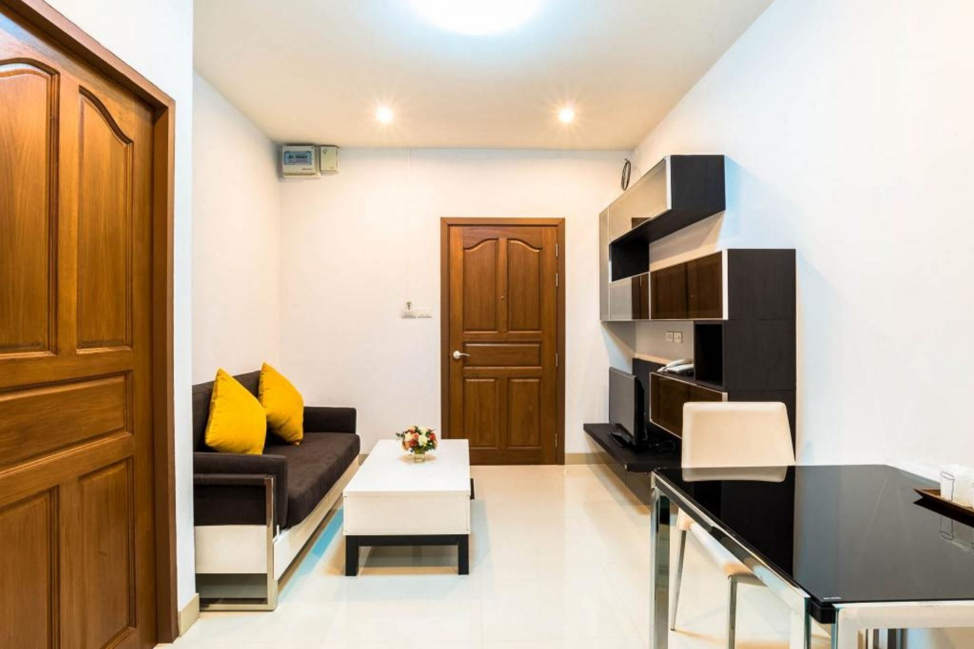 A compact living space with a sofa, coffee table, and built-in shelving unit.