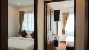 A hotel room with a bed, a desk, and a television.