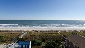 Une vue sur la plage avec un chemin menant à un bâtiment.