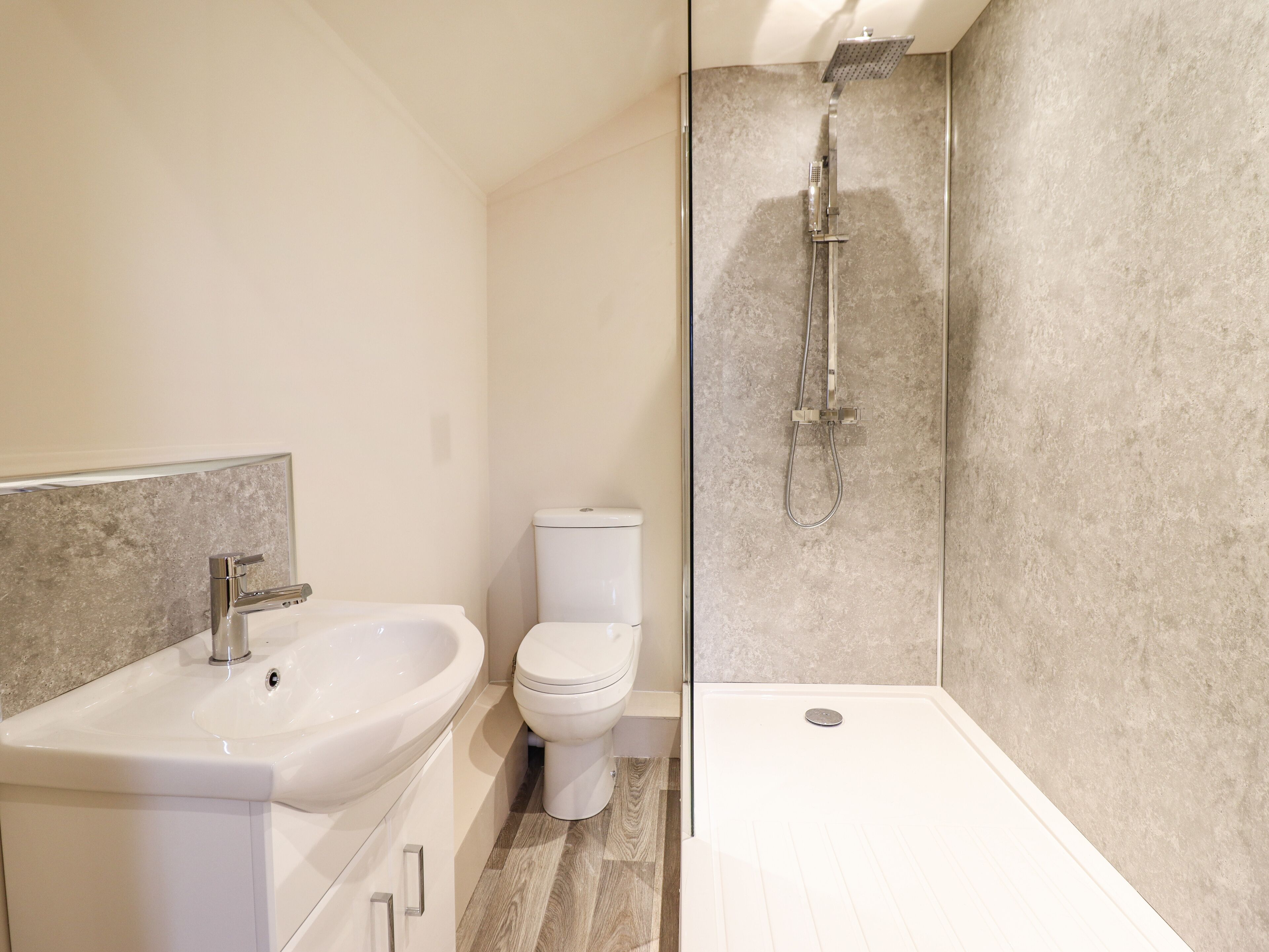 A modern bathroom with a sink, toilet, and shower.