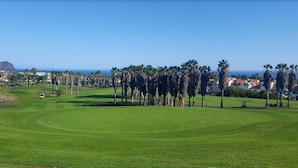 A golf course with a clear view of the ocean and a mountain in the distance. - Tropical Green Park - Pool - Parking - La Corbeta Building (San Miguel de Abona)