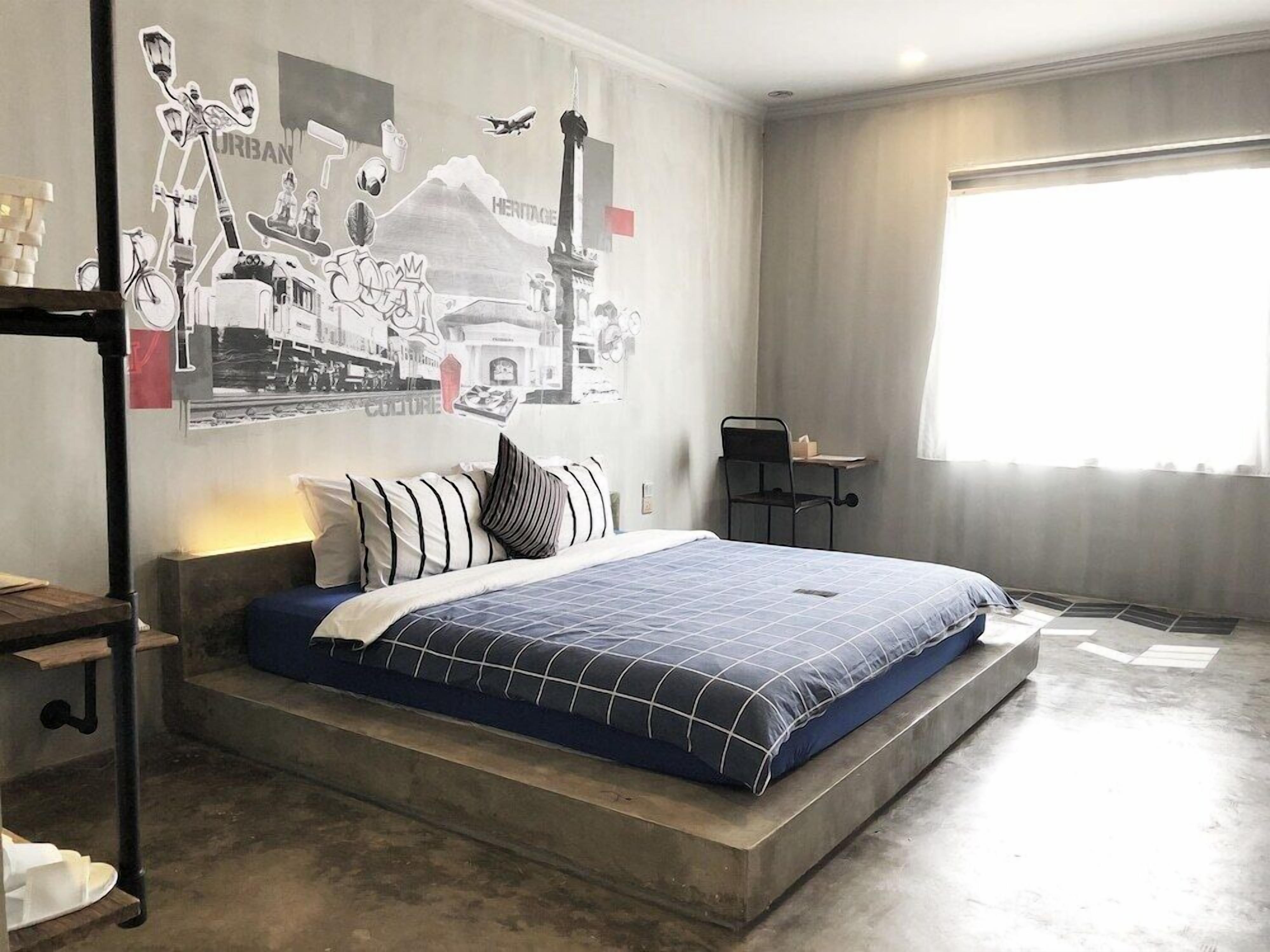 Un dormitorio moderno con una cama grande, un escritorio y una ventana.