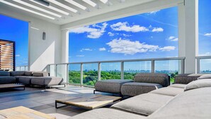 A modern outdoor lounge area with a city view, large windows, and a minimalist design. - One Bedroom Condo King Bed With City Views (Miami)