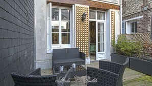 Un espace extérieur aménagé avec des meubles en osier et une terrasse en bois.