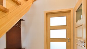 A wooden staircase leading to a room with a wooden door and a dresser. - Apartamenty Swinoujscie - Casa Marina (Swinoujscie)
