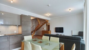 A modern apartment with a kitchen, dining area, and living room. - Apartamenty Swinoujscie - Casa Marina (Swinoujscie)