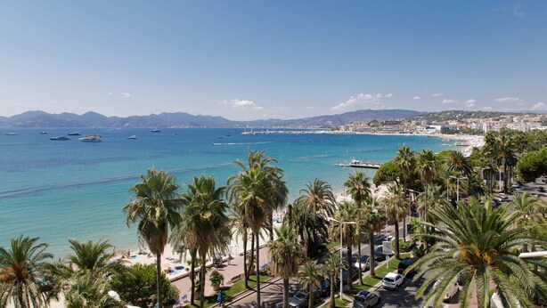 A coastal cityscape with a beach, palm trees, and boats in the water. - On la Croisette XXL 1 bedroom with amazing sea view (Cannes)