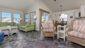 A spacious living room with a herringbone floor, green and striped wicker sofas, a white side table, and a ceiling fan. - IDEAL LOCATION - ONLY A BLOCK AND A HALF TO BEACH- 208 Fourth Street, Bethany (Bethany Beach)