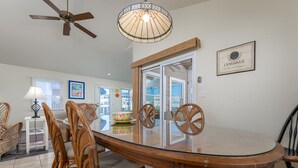 A dining area with a glass-top table, wicker chairs, a ceiling fan, and a chandelier. - IDEAL LOCATION - ONLY A BLOCK AND A HALF TO BEACH- 208 Fourth Street, Bethany (Bethany Beach)