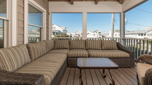 A covered outdoor seating area with a large sectional sofa, a small table, and wicker furniture. - IDEAL LOCATION - ONLY A BLOCK AND A HALF TO BEACH- 208 Fourth Street, Bethany (Bethany Beach)