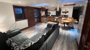 A modern apartment with a living room, kitchen, and dining area. - Ochiltree Cottage, Waterside Newton Stewart. (Polbae)